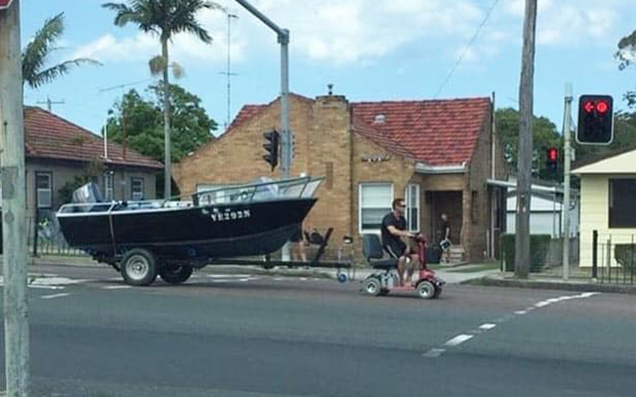Bloke In NSW Charged For The Apparent Crime Of Towing A Boat With A Scooter
